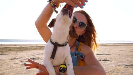 stilvolle-junge-Hipster-spielenden-Hund-Welpen-jack-Russell-am-Strand,-Slow-motion