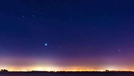 niebla-y-un-cielo-estrellado-en-el-movimiento-por-encima-de-las-luces-de-un-horizonte-de-la-ciudad