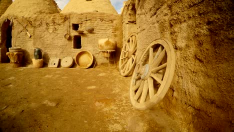 wooden-wheels,-old-utensils-and-clay-house-in-the-Arab-village,-near-the-border-between-Turkey-and-Syria