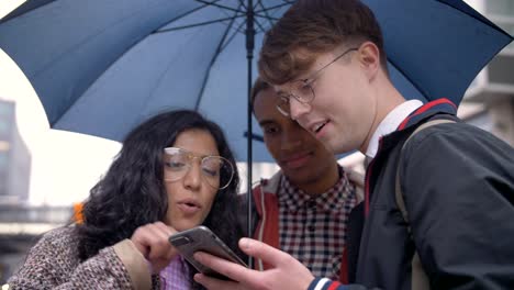 Young-people-are-friends-of-different-nationalities-came-under-rain-in-Berlin-and-studying-the-transport-scheme-and-short-route