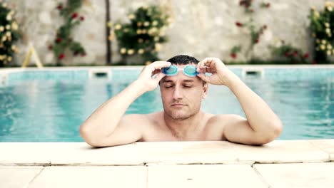 Man-put-googles-and-swimm-crowl-in-luxury-swimming-pool,-cinematic-dof