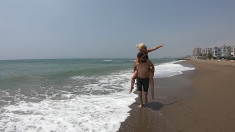 Young-couple-laughing-and-having-fun-on-a-beach.