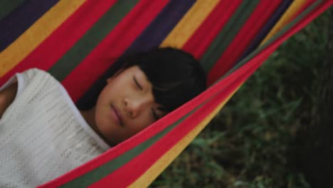 Little-girl-resting-lying-on-hammock-outdoors-in-slow-motion