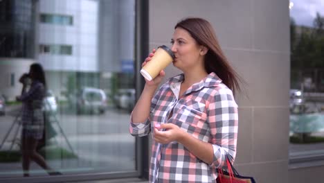 Niña-va-después-de-compras-con-bolsas-en-sus-manos-tomando-café.-4K