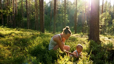 Mutter-und-Sohn-im-Alter-von-einem-Jahr-sammeln-und-Essen-wilde-Blaubeeren