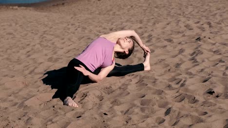 Mujer-de-estiramientos-yoga-en-la-playa-de-la-ciudad.-Sirsasana,-supra-upavistha-konasana-pose.