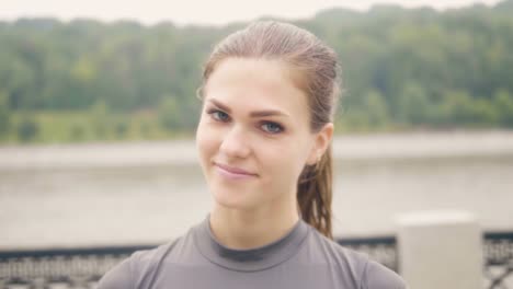 Face-beautiful-woman-smiling-and-waving-hand-into-camera-outdoor.