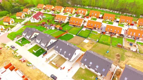 Camera-flight-over-new-family-houses-and-construction-site-in-suburban-district.-Construction-industry-and-economic-growth-in-European-Union.