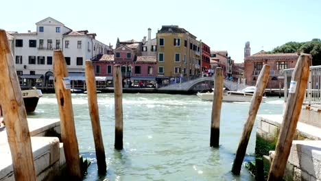 views-of-Venice,-grand-canal,-mooring-for-gondolas,-vapareto-floats-on-water,-small-boats,-gondolas-sail,-on-a-hot-summer-day