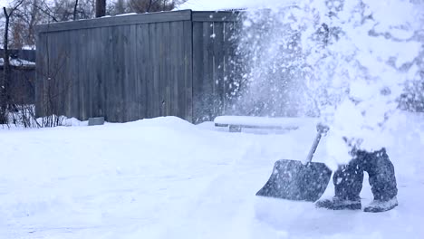 Work-after-snowy-night.-Man-with-a-shovel-removing-the-snow-from-his-yard-on-a-cold-snowy-morning