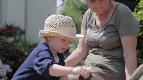 Kind-spielt-mit-Felsen-von-einem-Outdoor-Brunnen