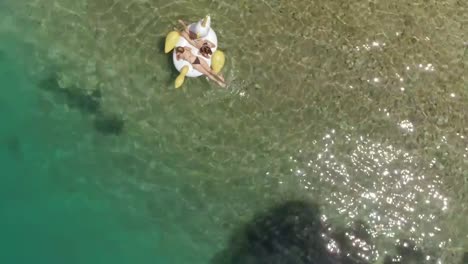 Luftaufnahme-von-zwei-Frauen,-die-in-Panagopoula,-Griechenland,-auf-aufblasbare-Weise-schwimmen.