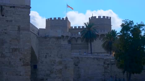 Beautiful-ancient-castle-with-graceful-serrated-towers-and-flag-of-Valencia