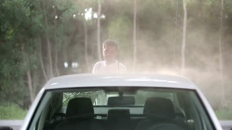 Man-in-a-t-shirt-white-car-washes.-Slow-motion