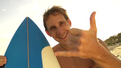 Cheerful-young-man-showing-surf-sign-with-his-hand