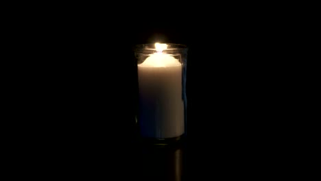 Slow-motion-macro-footage-of-a-white-candle-on-a-dark-background