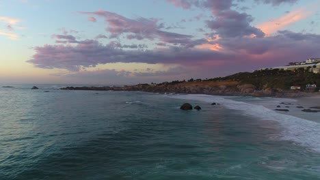 Cape-Town-Camps-Bay-Beach-Aerial-with-Beautiful-Pink-Sunset-over-Rocks