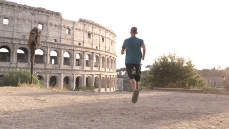 Hombre-en-ropa-deportiva-de-conducción-y-la-parada-en-una-colina-frente-al-Coliseo-de-Roma-al-atardecer