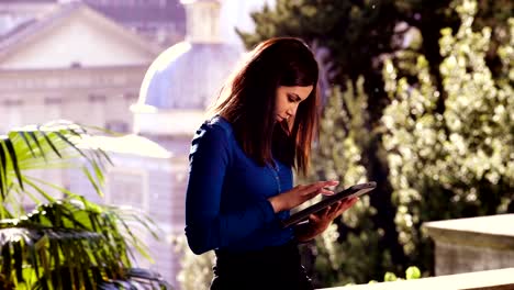 Profile-of-beautiful-Asian-woman-in-a-park-while-using-the-tablet