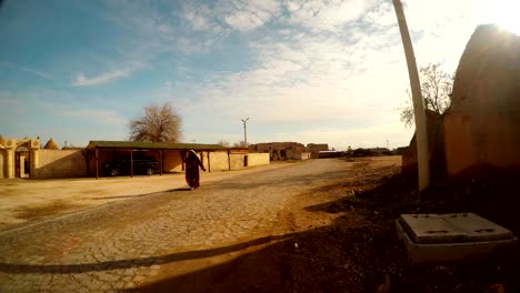 una-mujer-árabe-camina-a-lo-largo-de-una-calle-de-la-aldea-en-la-frontera-entre-Siria-y-Turquía