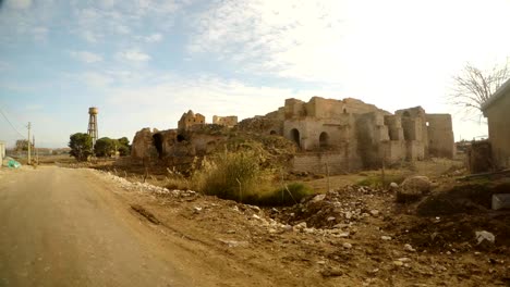 Ruinen-einer-alten-Burg-und-eine-Straße-in-einem-kleinen-arabischen-Dorf,-nahe-der-Grenze-zwischen-der-Türkei-und-Syrien