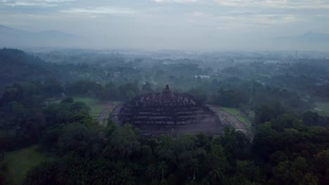 Tiro-de-drone-de-vista-aérea-del-templo-de-Borobudur-en-Java-al-amanecer,-viajes-Indonesia-religión-drone-concepto-4K-de-resolución