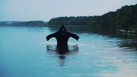 Evil-witch-in-black-cloak-with-hood-in-the-river.