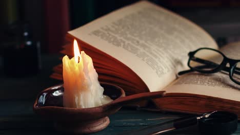 Time-lapse-candle-and-old-books-at-night-time.-Close-up-view.-Cinematic-color-grading.