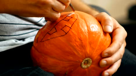 mit-einem-Messer-schnitzen-einen-Halloweenkürbis