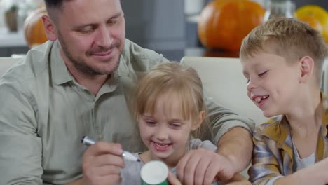 Smiling-Man-Drawing-on-Party-Cup-with-Children
