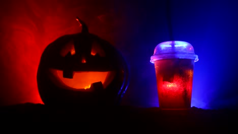 Halloween-pumpkin-orange-cocktails.-Festive-drink.-Halloween-party.-Funny-Pumpkin-with-a-glowing-cocktail-glass-on-a-dark-toned-foggy-background.-Selective-focus