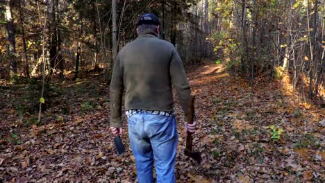 Man-in-Halloween-mask-and-axe-alone-on-path-in-park