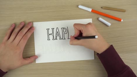 Women's-hands-drawing-Happy-Halloween-inscription-timelapse