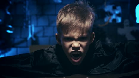 Young-boy-in-a-vampire-costume-for-Halloween-showing-his-scary-face-and-teeth-to-camera