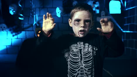 Scary-little-boy-wearing-skull-makeup-for-Halloween-using-fingers-to-scare