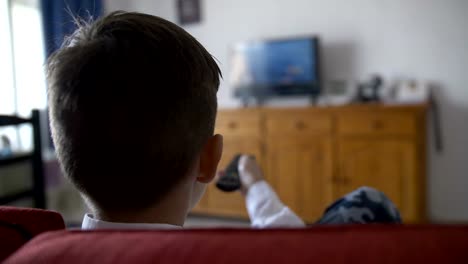 boy-sits-on-the-sofa-in-front-of-the-TV-and-switches-the-channels