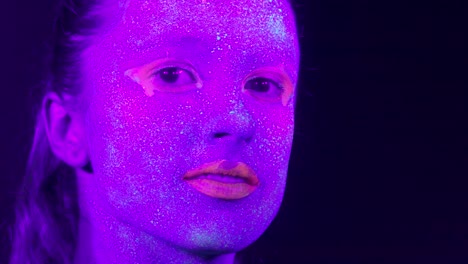 Closeup-woman-face-with-fluorescent-make-up,-creative-makeup-look-great-for-nightclubs.-Halloween-party,-shows-and-music-concept---slow-motion-video