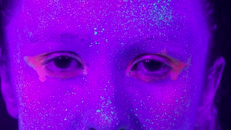 Primer-plano-ojos-de-mujer-con-maquillaje-fluorescente,-maquillaje-creativo-lucen-muy-bien-para-discotecas.-Concepto-de-fiesta,-espectáculos-y-música-de-Halloween---slow-motion-video