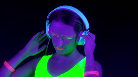 Slow-motin-of-beautiful-sexy-women-with-fluorescent-make-up-and-clothing-dancing-in-neon-light.-Night-club,-Party-Concept.