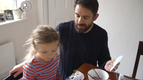 Padre-e-hija-haciendo-máscaras-de-Halloween-en-casa-juntos