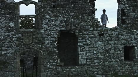 4k-Horror-Shot-of-an-Abandoned-Child-Appearing-in-the-Window-of-a-Ruined-Castle