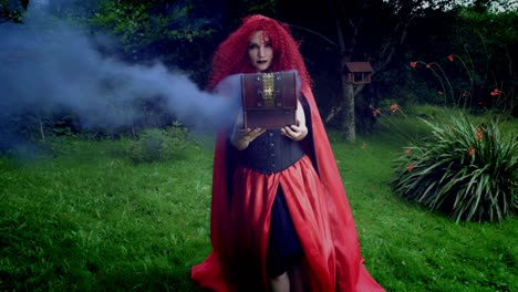 4k-Halloween-Shot-of-Red-Riding-Hood-Holding-a-Box-with-Coloured-Smoke