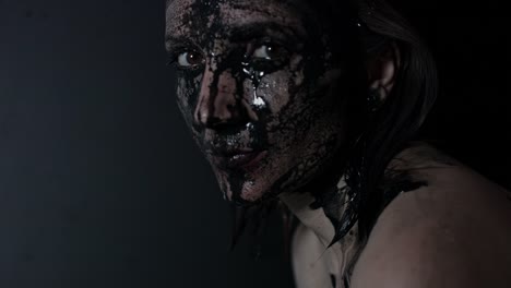 4k-shoot-of-a-horror-Halloween-model---Woman-washing-black-mud-and-smiling