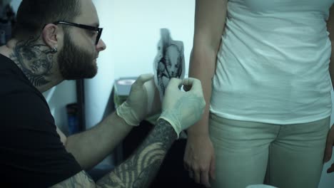 4-k-dibujo-del-tatuaje-artista-preparando-en-el-brazo-del-cliente