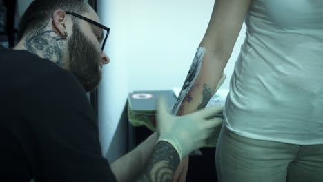 4k-Tattoo-Artist-Preparing-Client's-Hand-with-Drawing