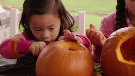 Young-girls-carving-pumpkin-for-Halloween