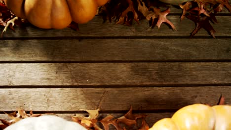 Calabaza-de-Halloween-con-la-hoja-de-arce-en-una-mesa-de-madera-4k