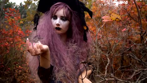 Junge-Rosa-Haare-Hexe-in-Hut-Suche-Reagenzien-in-den-mystischen-herbstlichen-Wald.-Halloween-Vorbereitung.