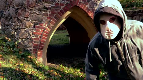 Man-with-Halloween-mask-and-machete-walking-near-to-camera