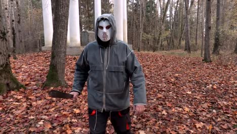 Mann-in-scary-Halloweenmaske-und-Machete-zu-Fuß-vor-der-Kamera